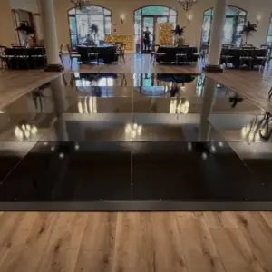 Luxury glossy black dance floor rental for weddings in Miami with oversized 4x4 premium panels.