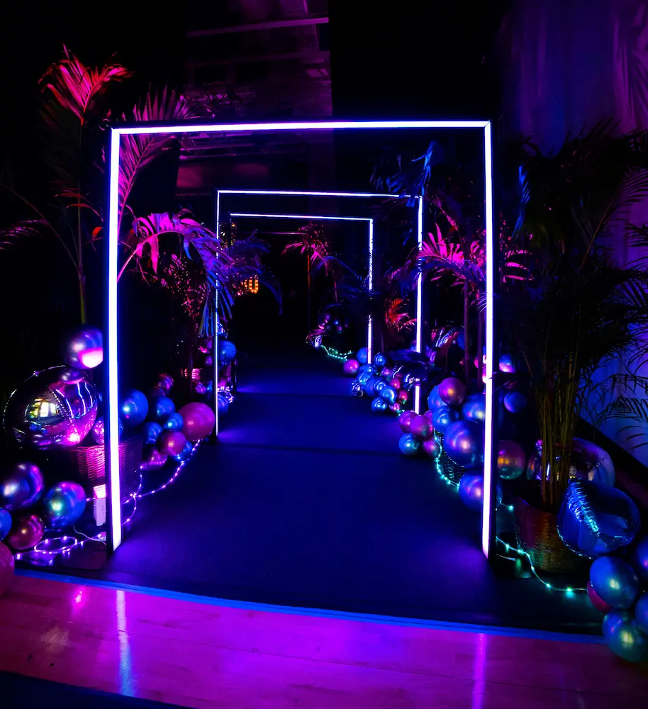 Rectangular LED entrance tunnel with illuminated arches and walkway at a Coral Gables school dance