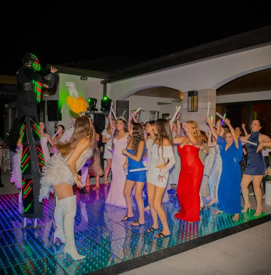 Professional female dancers and LED Robot performing Hora Loca on a Pixel LED dance floor at a Miami quinceañera