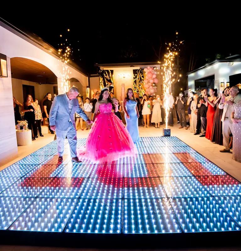 Quinceañera entering with her parents beside cold sparklers and a Pixel LED dance floor at an outdoor Kendall Miami celebration