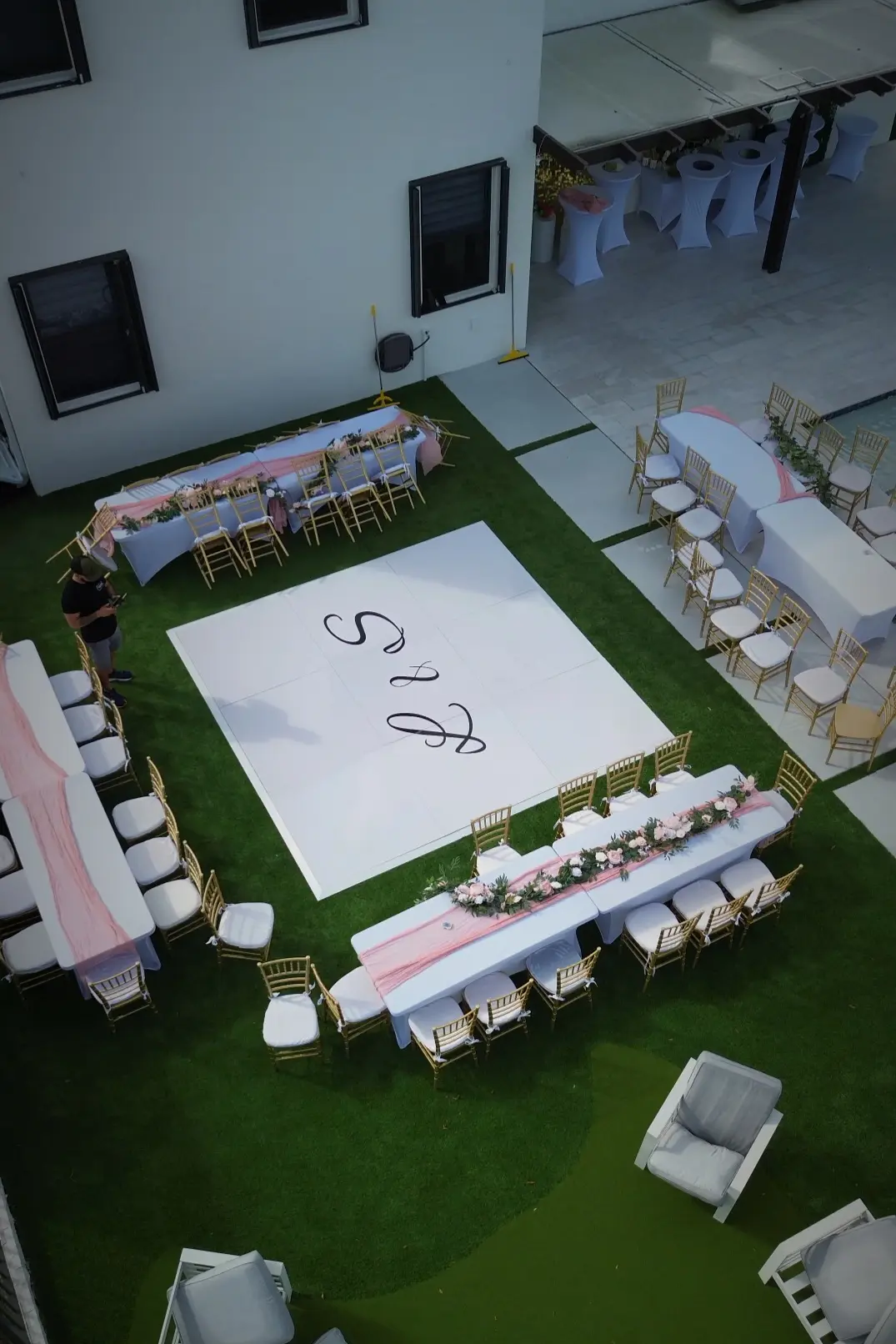 Aerial view of a 12 by 12 white wedding dance floor surrounded by guest seating at a Miami backyard wedding