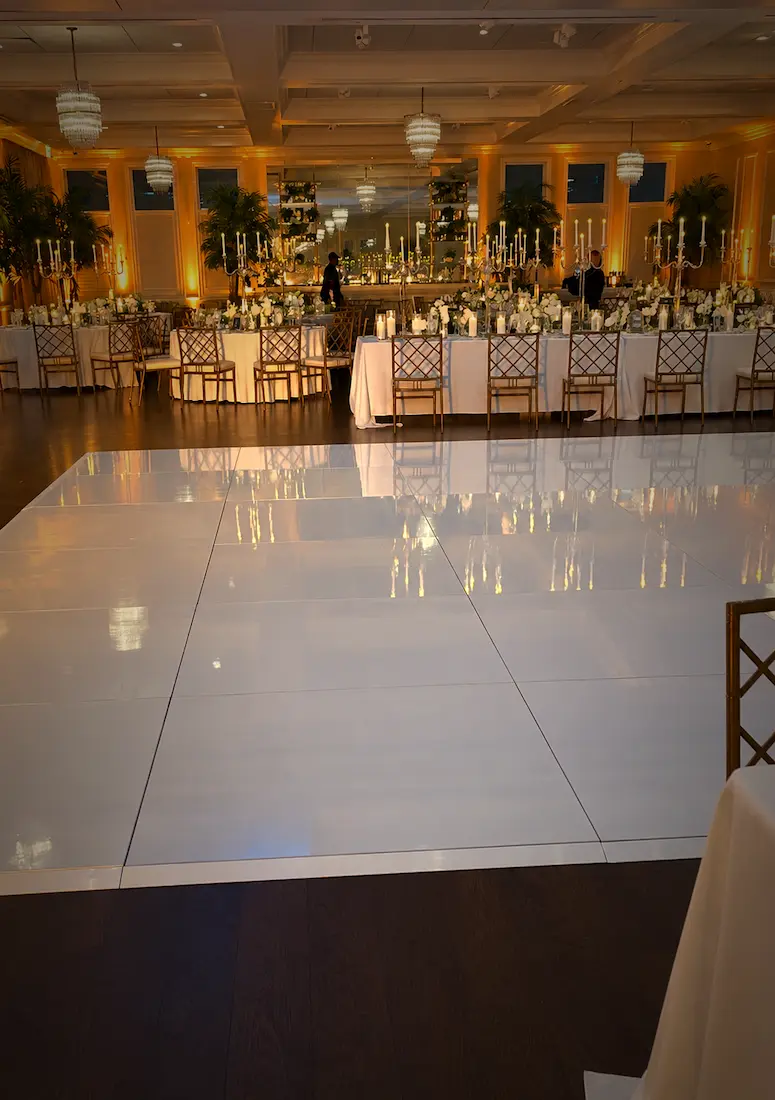 White wedding dance floor with amber wireless uplighting around a Palm Beach County reception room