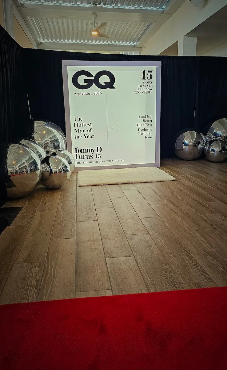 Mixed-size silver inflatable mirror balls arranged around a Magazine Cover Booth at a Boca Raton birthday party