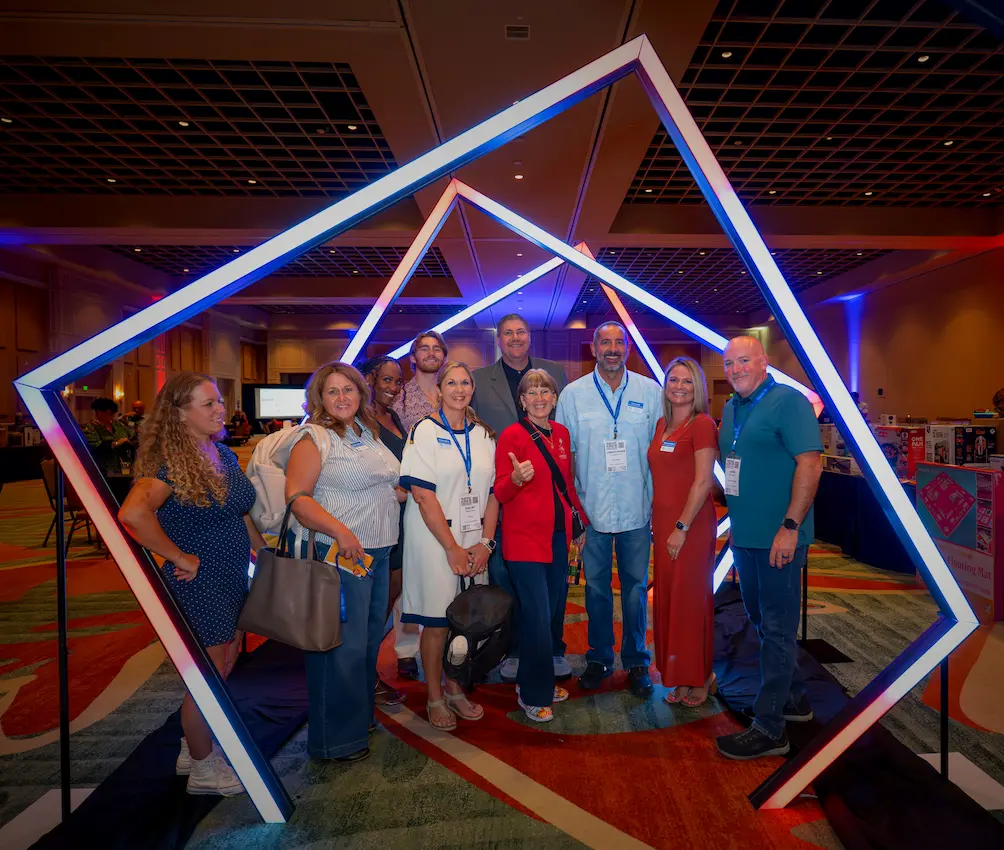 Corporate event attendees posing inside an illuminated geometric LED entrance at the Florida Realtors event