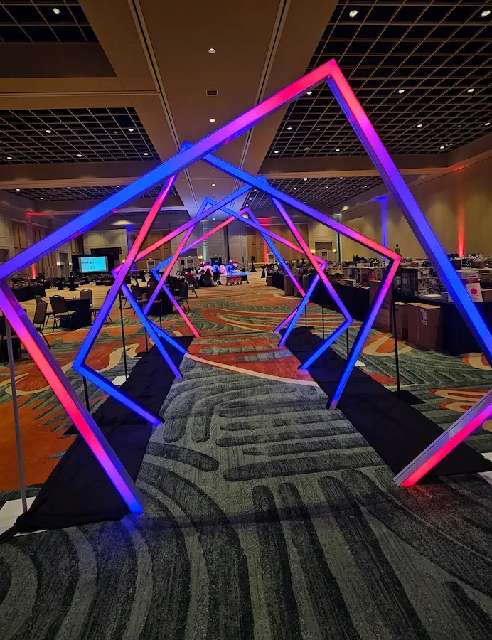 Illuminated geometric LED tunnel entrance at a corporate event