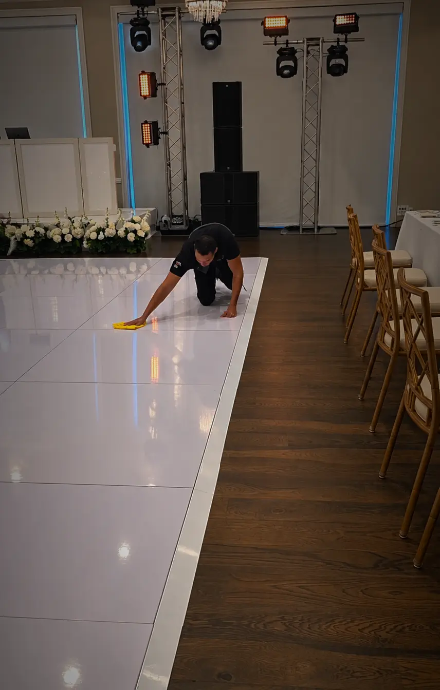 Special Memories FL team member cleaning a glossy white wedding dance floor before guest arrival
