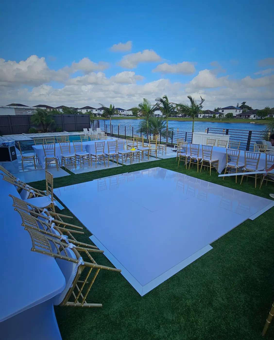 Glossy white dance floor installed on flat artificial grass for an outdoor Miami wedding