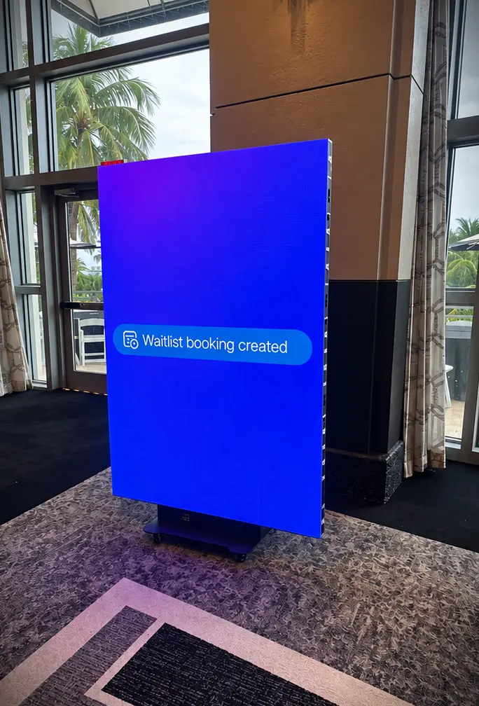 Trade show LED screen displaying booking software content at Loews Miami Beach Hotel