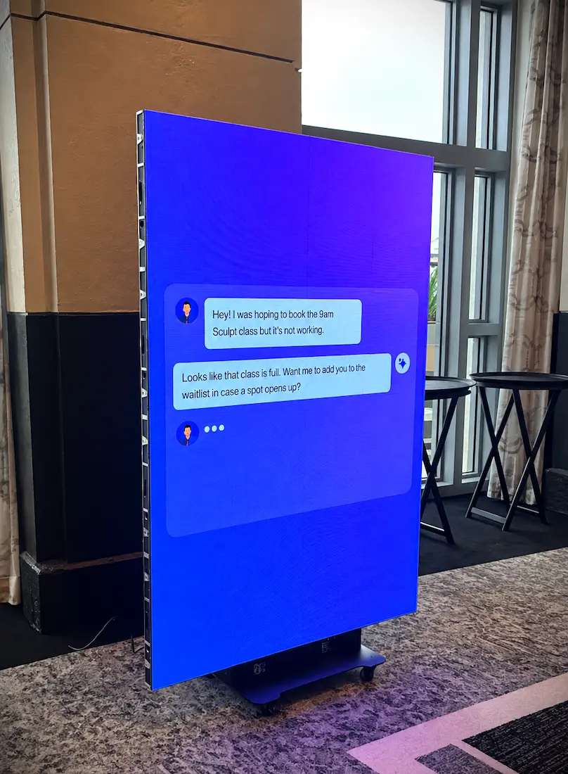 Vertical LED display showing Xplor Momence booking content during The Pilates Journal Expo in Miami