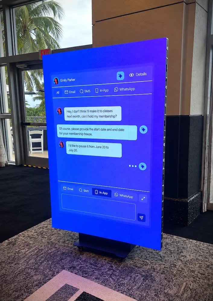 Freestanding vertical LED display showing Xplor Momence product content at The Pilates Journal Expo in Miami Beach
