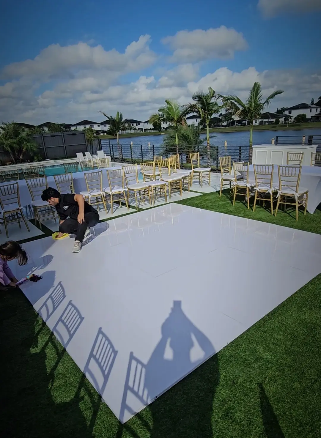 Special Memories FL team member cleaning a glossy white wedding dance floor before a Miami backyard wedding