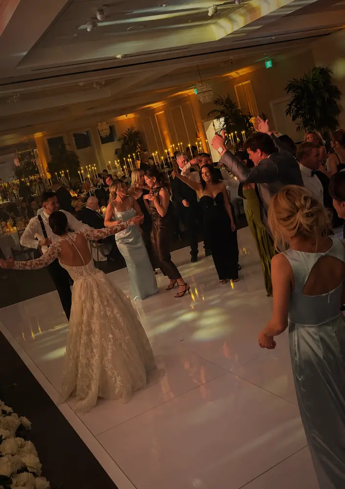 Bride and wedding guests dancing on a glossy white dance floor during a Jupiter reception