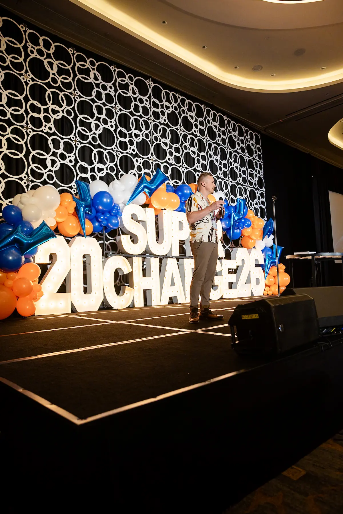 Speaker on the Supercharge 2026 conference stage at Pier Sixty-Six in Fort Lauderdale