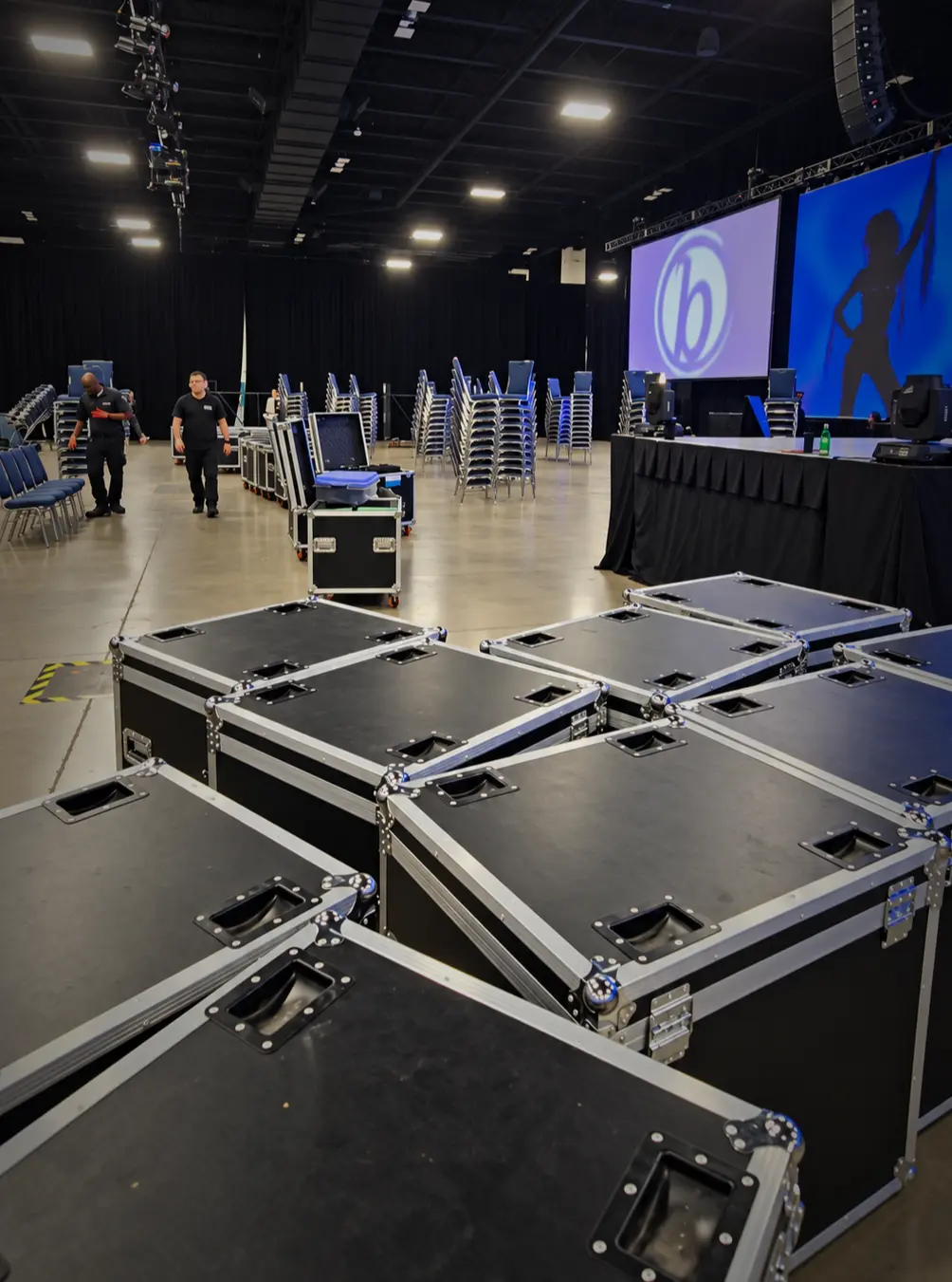 Equipment cases and crew in the convention hall during event setup