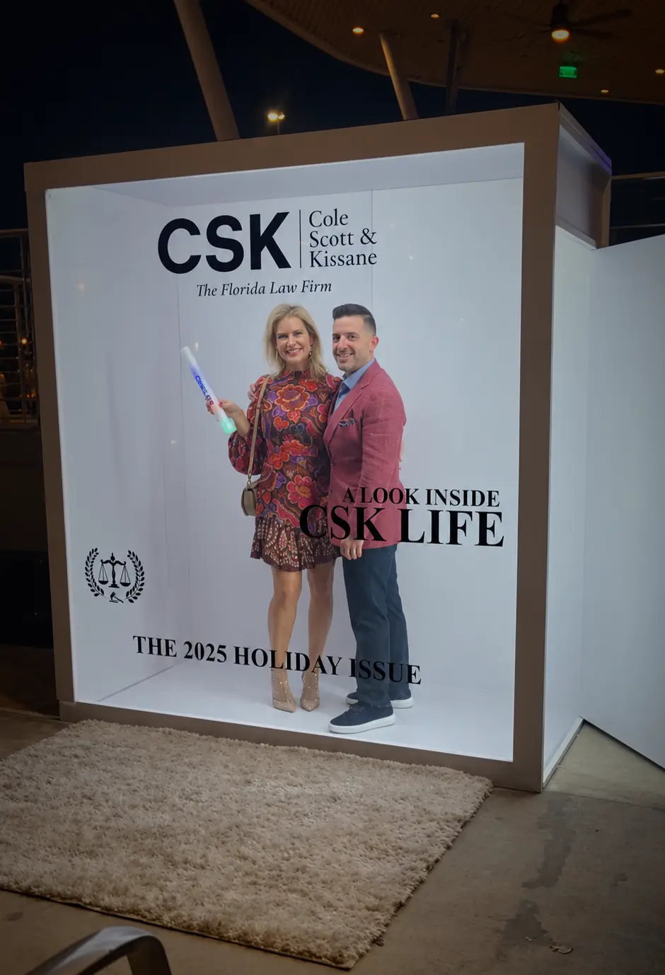 Guests posing inside a custom CSK Magazine Cover Booth at the corporate holiday celebration in Coconut Grove