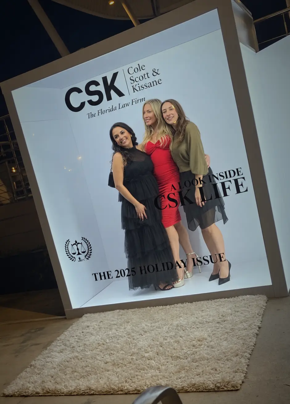Three guests posing together inside the CSK magazine cover photo booth in Coconut Grove, Miami