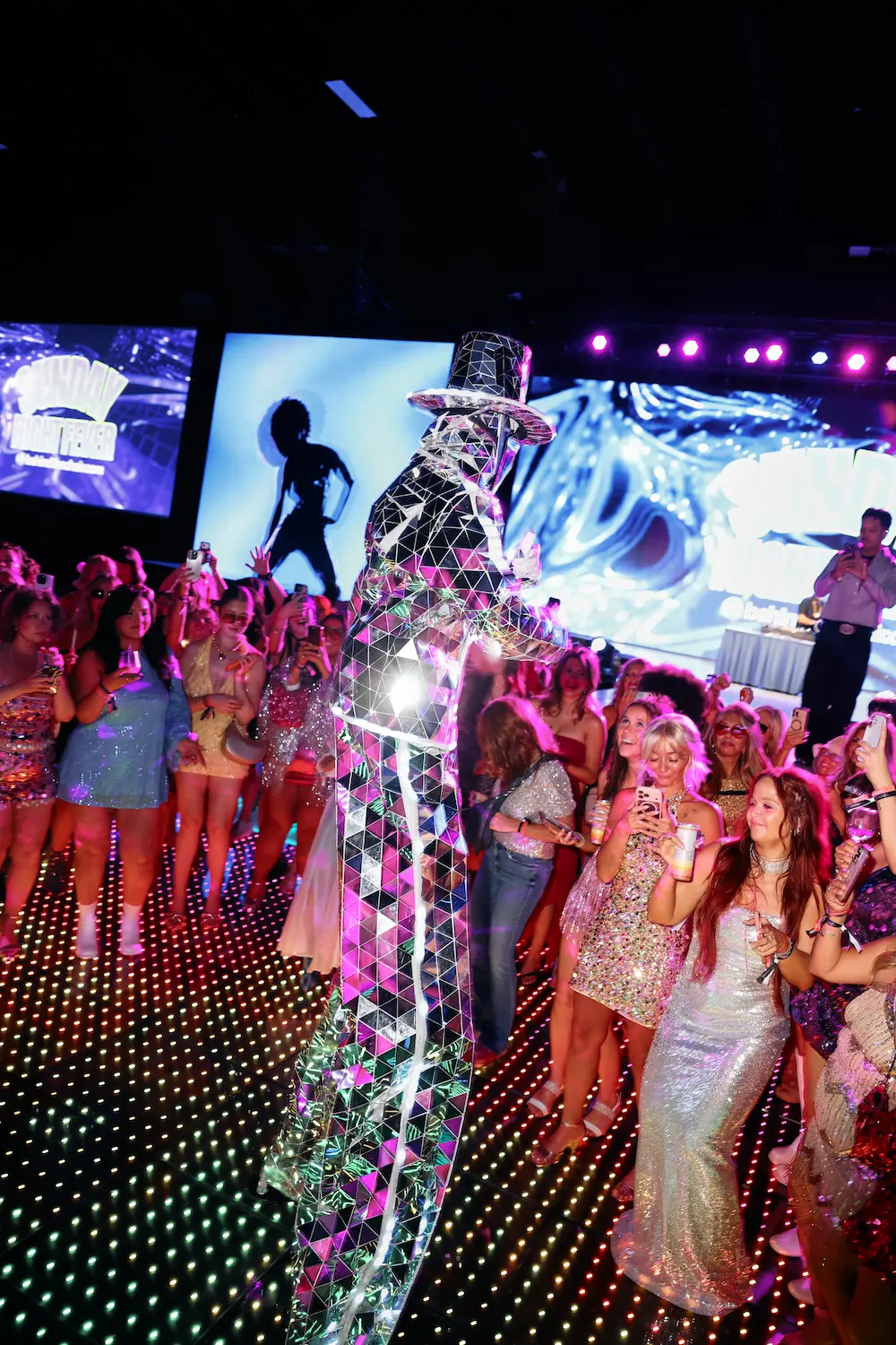 A mirrored stilt walker among guests on the Pixel LED dance floor at Sunday Night Fever
