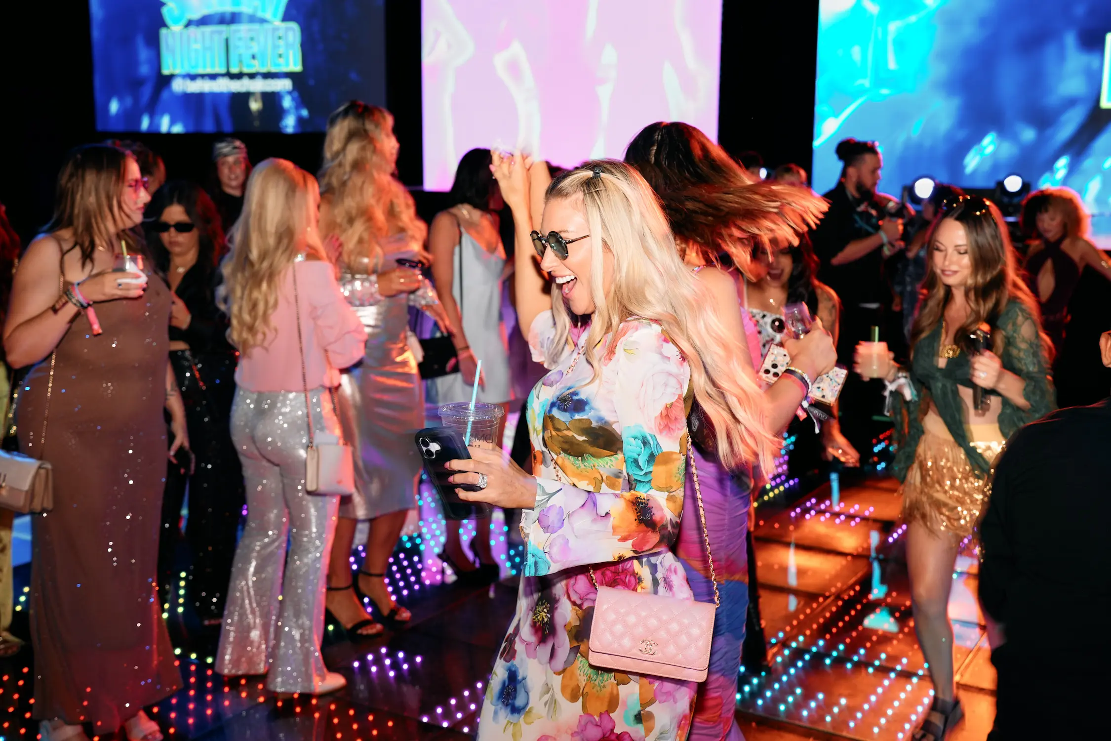 Guests dancing over multicolored LED patterns during Behind the Chair’s Sunday night party